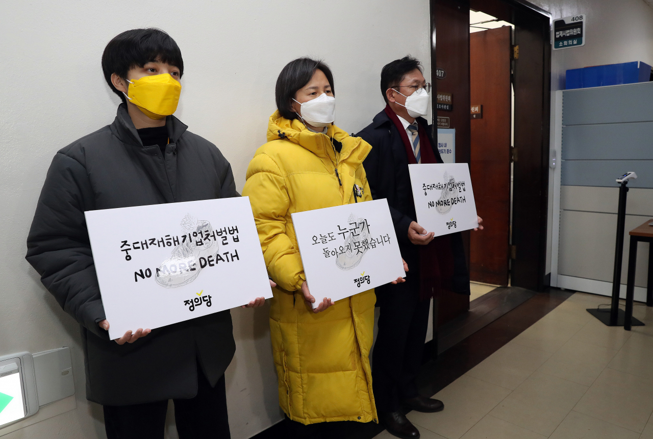 정의당 강은미 원내대표(가운데), 배진교(오른쪽), 류호정 의원이 24일 오전 서울 여의도 국회에서 열린 법사위 법안심사소위 회의장 앞에서 중대재해기업처벌법 제정을 촉구하는 피켓을 들고 있다. [연합]