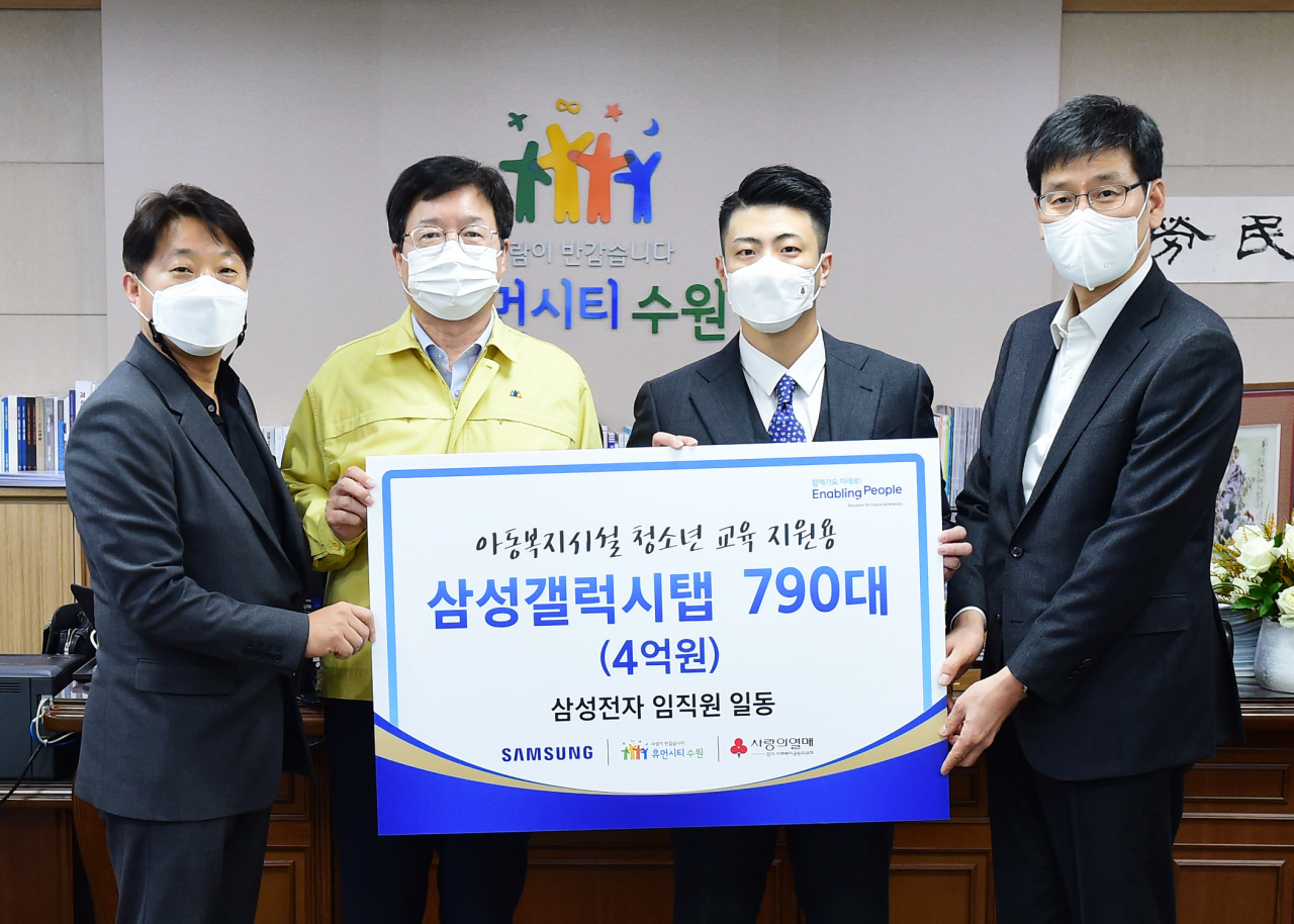 염태영 시장(왼쪽 2번째), 삼성전자 나기홍(인사팀장) 부사장(오른쪽 1번째), 최장원(오른쪽 2번째) 사원대표, 송봉섭 전무(왼쪽 2번째)가 전달식 후 기념촬영을 하고 있다.[수원시 제공]