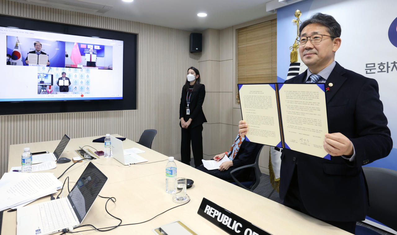 박양우 문화체육관광부 장관이 24일 서울 용산구 문체부스마트워크센터 회의실에서 비대면으로 열린 제3회 한·일·중 스포츠장관회의에 참석해 한일중 올림픽·패럴림픽 계기 스포츠 교류 및 협력 강화 공동성명서에 서명한 뒤 화상을 통해 하기우다 코이치 일본 문부과학성 대신과 거우중원 중국 국가체육총국 국장과 함께 기념촬영을 하고 있다. [문체부 제공]