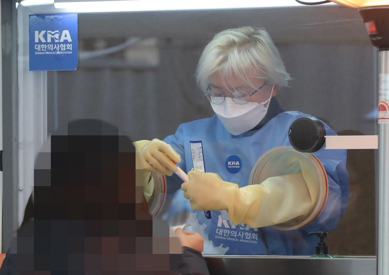 28일 오전 서울광장 임시선별진료소에서 한 의료진이 검체 채취를 하고 있다. 중앙방역대책본부는 이날 0시 기준으로 코로나19 신규 확진자가 808명 늘어 누적 5만7천680명이라고 밝혔다. 연합뉴스