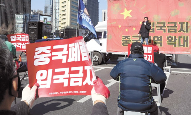 코로나19 사태가 악화일로에 있던 지난 2월 서울 종로구 청계광장 인근에서 열린 자유대한호국단 주최 ‘입국금지 조치 중국 전역 확대 촉구’ 집회에서 참석자들이 ‘중국폐렴 입국금지’라고 적힌 손피켓을 들고 있다. [연합]