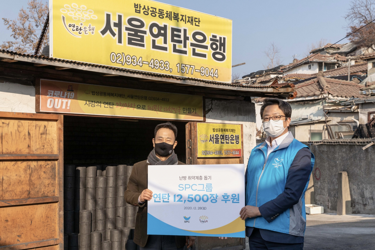 28일 서울 노원구에 위치한 사회복지법인 밥상공동체 연탄은행에서 열린 ‘SPC행복한재단 연탄 전달식’에서 관계자들이 기념촬영을 하고 있다. 왼쪽부터 허기복 사회복지법인 밥상공동체 연탄은행 대표, 백승훈 SPC행복한재단 상무.[SPC그룹 제공]