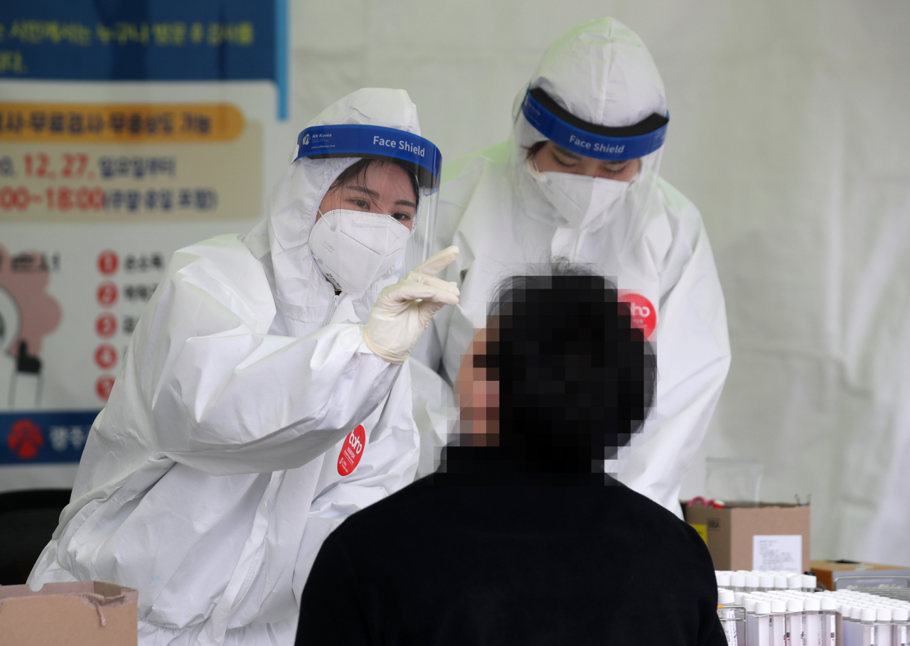 29일 오전 광주광역시 시청광장에 설치된 코로나19 임시 선별검사소에서 의료진이 한 시민의 신종 코로나바이러스 감염증 검체를 채취하고 있다. [연합]