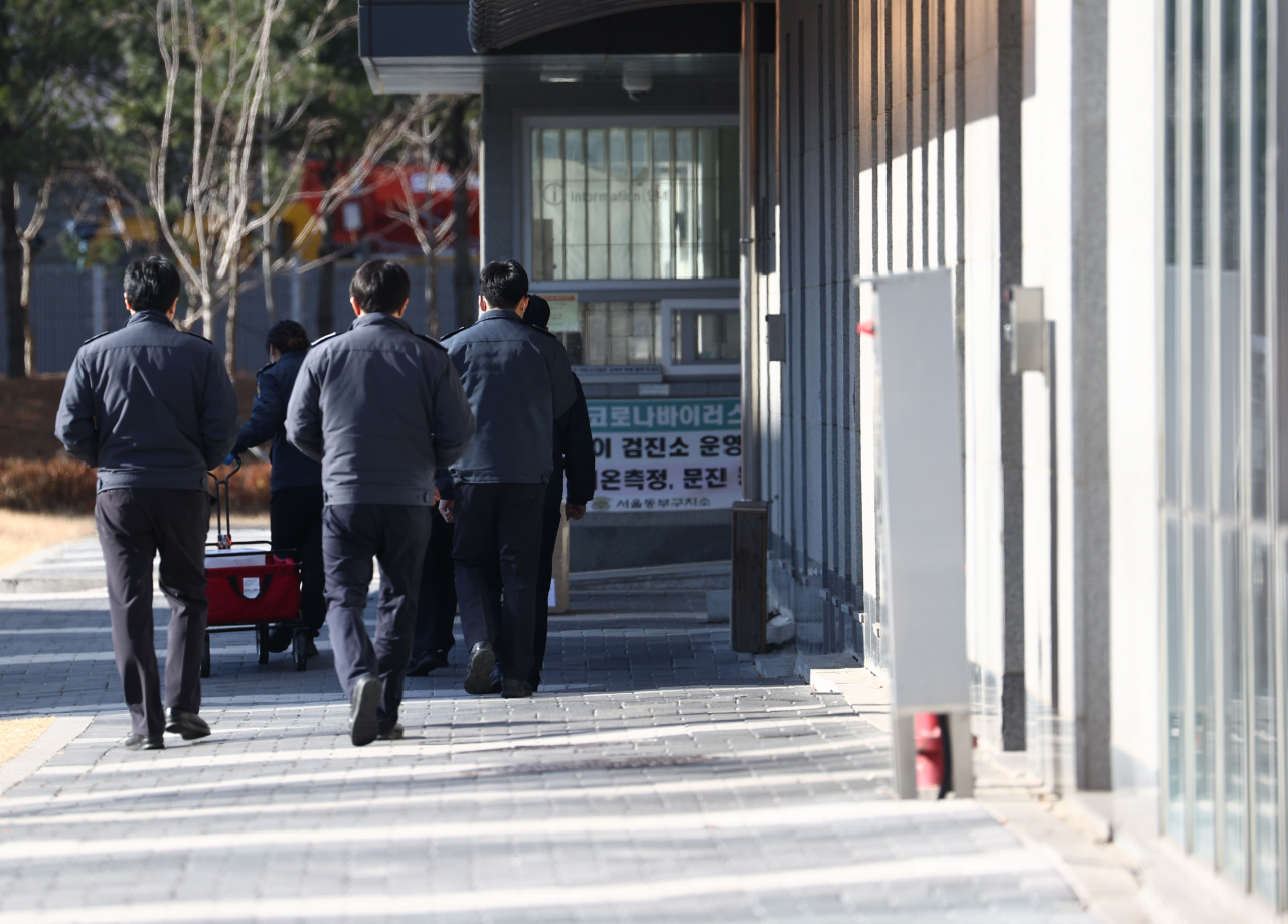 31일 코로나19 집단 감염이 발생한 서울 동부구치소에 관계자들이 지나고 있다. [연합]