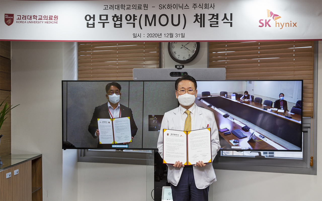 고려대학교의료원이 SK하이닉스와 업무협약을 체결했다. 김영훈 의무부총장 겸 의료원장이 협약서를 들고 포즈를 취하고 있다.