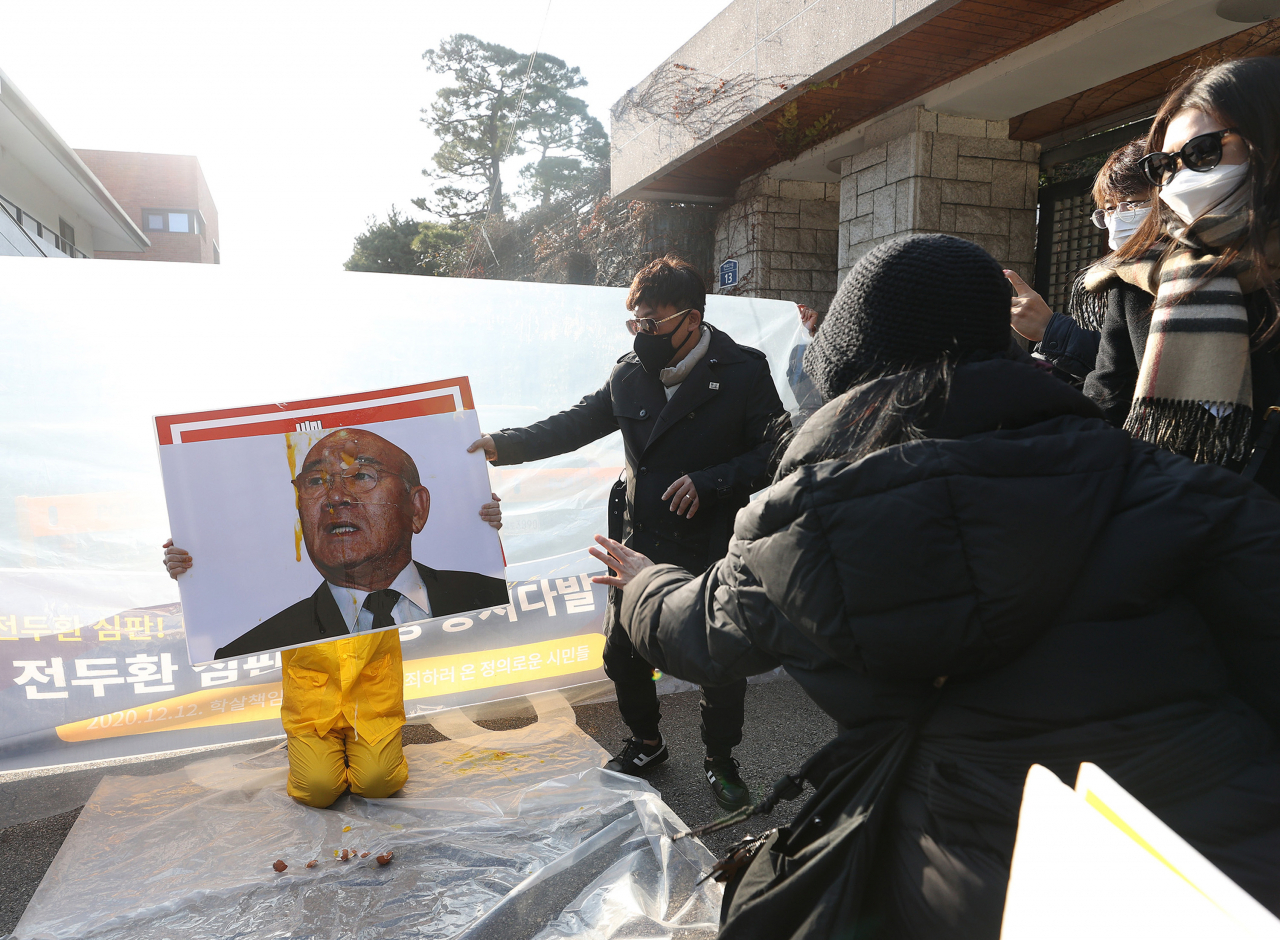 지난 12일 서울 서대문구 연희동 전두환 전 대통령 자택 인근에서 시민단체 회원들이 전 전 대통령 사진에 계란을 던지는 퍼포먼스를 하고 있다. [연합]