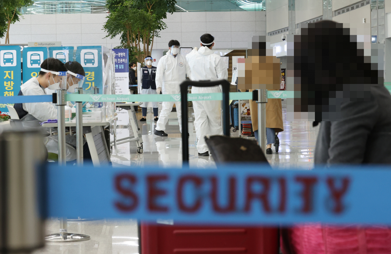 지난 2020년 12월 30일 오후 인천국제공항 제2여객터미널 입국장에서 일본 오사카발 항공편 해외입국자들이 방역 관계자들의 안내를 받고 있다.[연합]