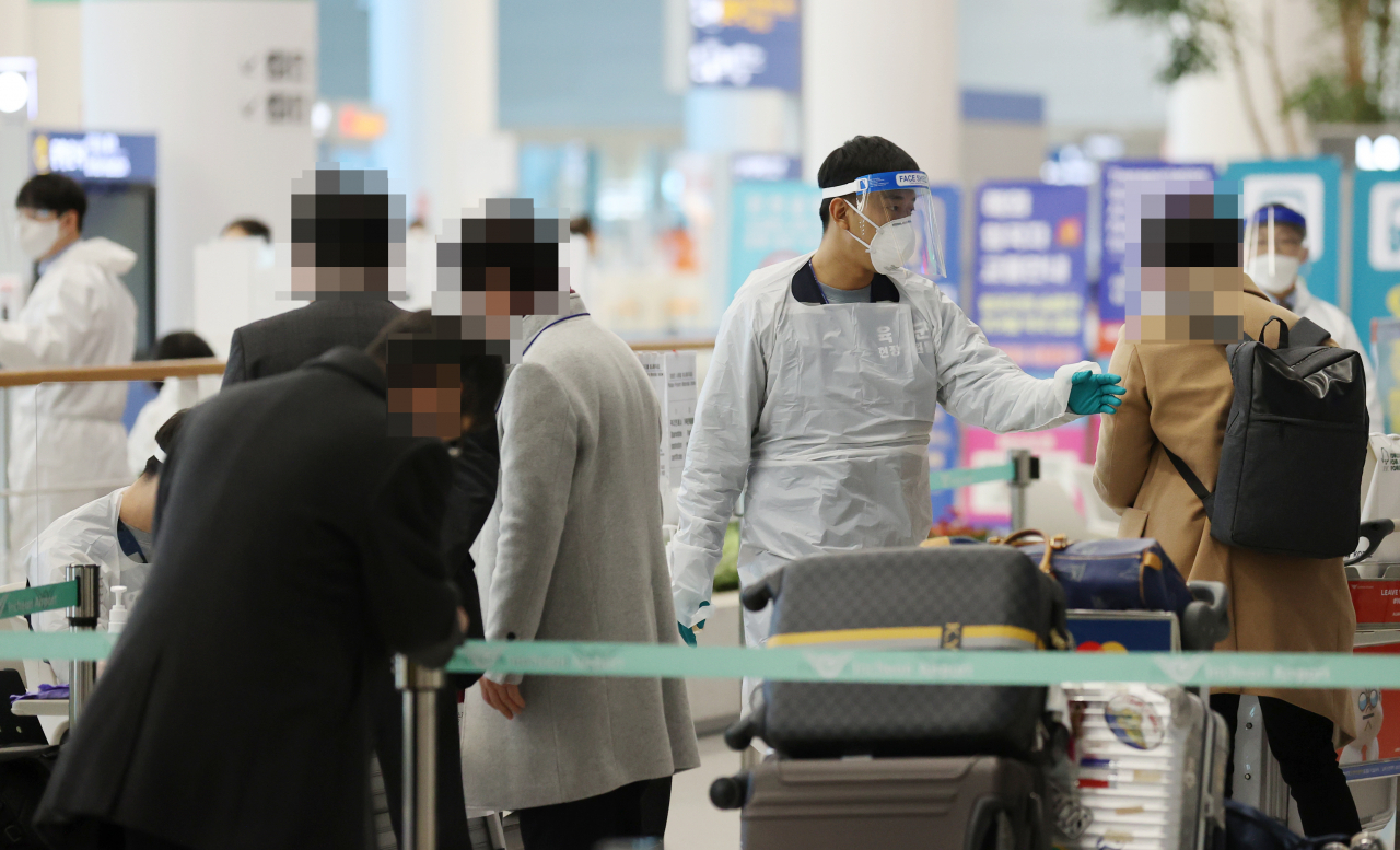 지난달 30일 오후 인천국제공항 제2여객터미널 입국장에서 일본 오사카발 항공편 해외입국자들이 방역 관계자들의 안내를 받고 있다. [연합]