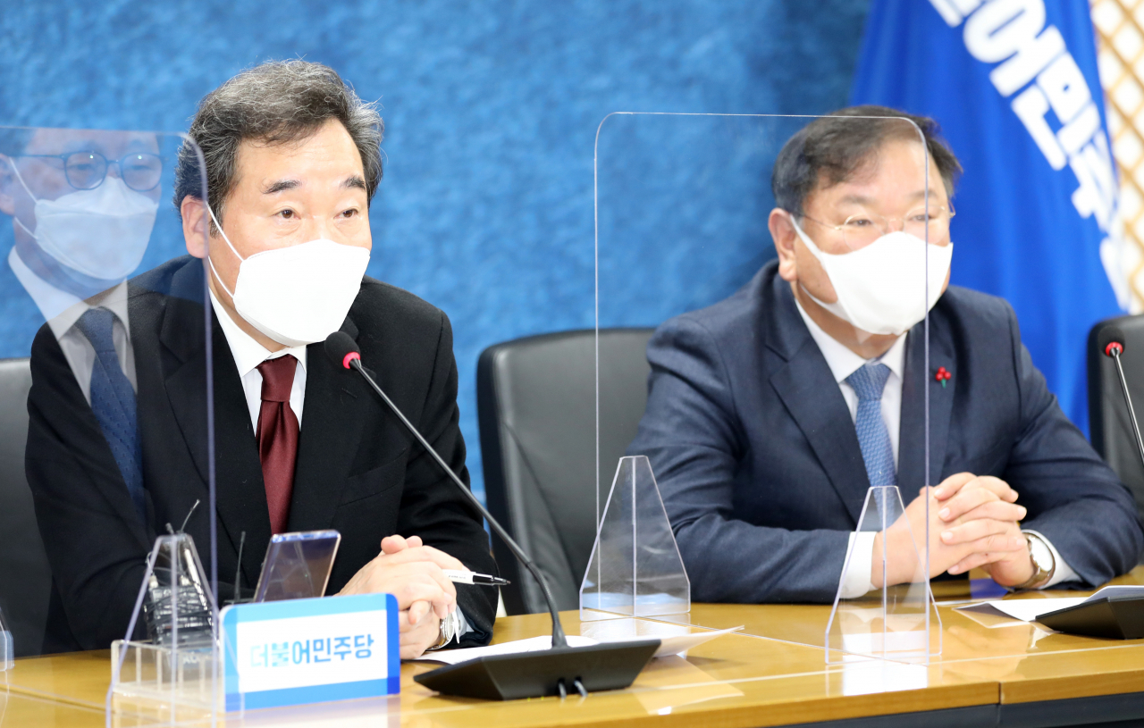 1일 오전 서울 여의도 당사에서 열린 더불어민주당 2021년 온택트 신년인사회에서 이낙연 대표(왼쪽)와 김태년 원내대표가 상임고문들의 새해 덕담을 영상으로 시청하고 있다. 연합뉴스
