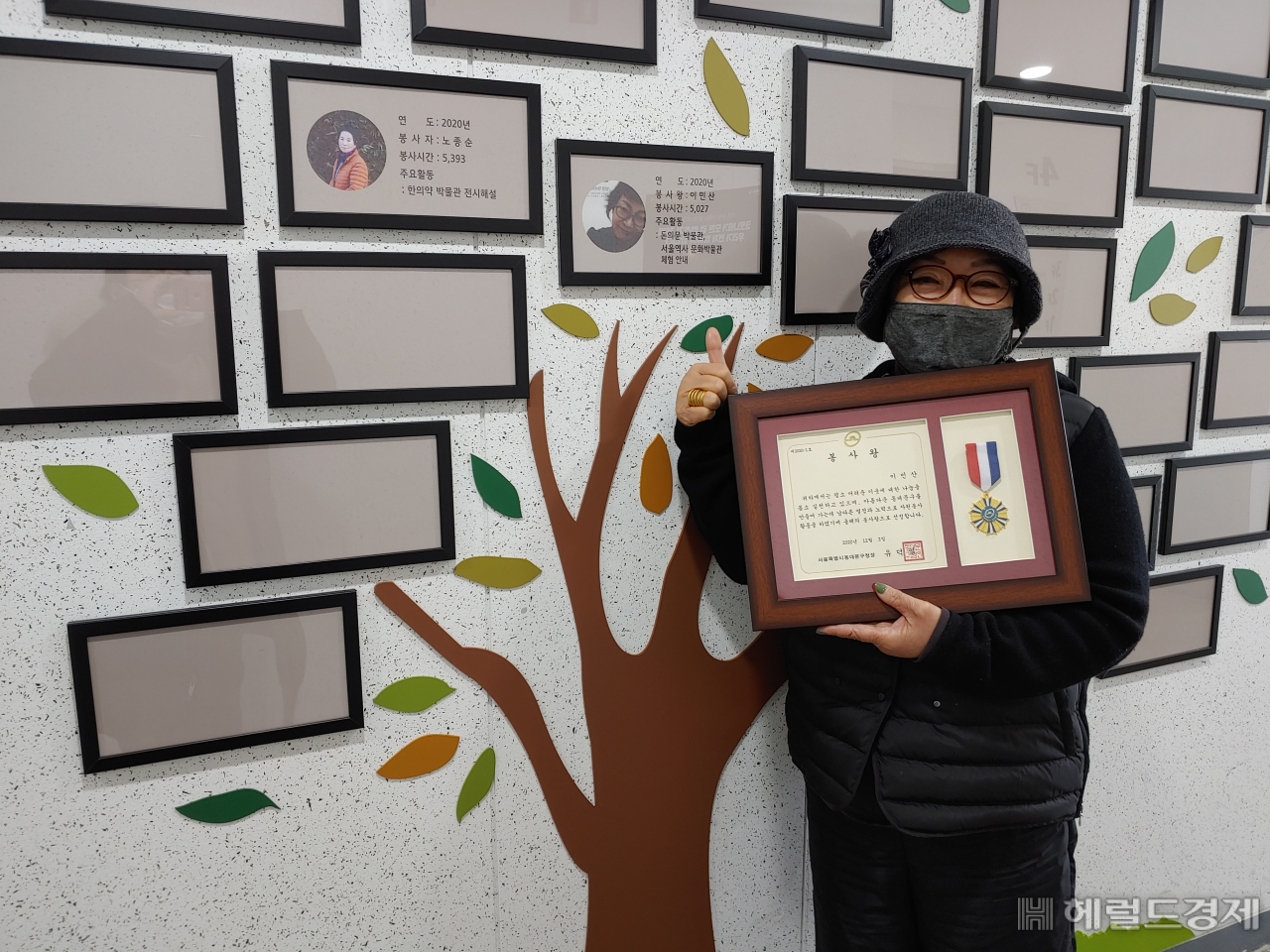 이민산 자원봉사자가 표창장을 받고 명예의 전당 앞에서 기념촬영을 하고 있다.[동대문구 제공]