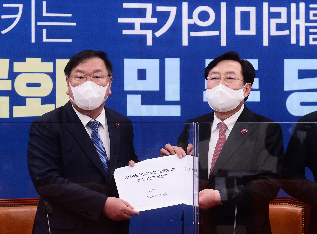 김태년 더불어민주당 원내대표가 4일 오후 서울 여의도 국회에서 열린 중대재해법 관련 중소기업단체 간담회에서 김기문 중소기업중앙회 회장으로 부터 '중대재해기업처벌법 제정에 대한 중소기업계 입장문'을 전달받고 있다. [연합]