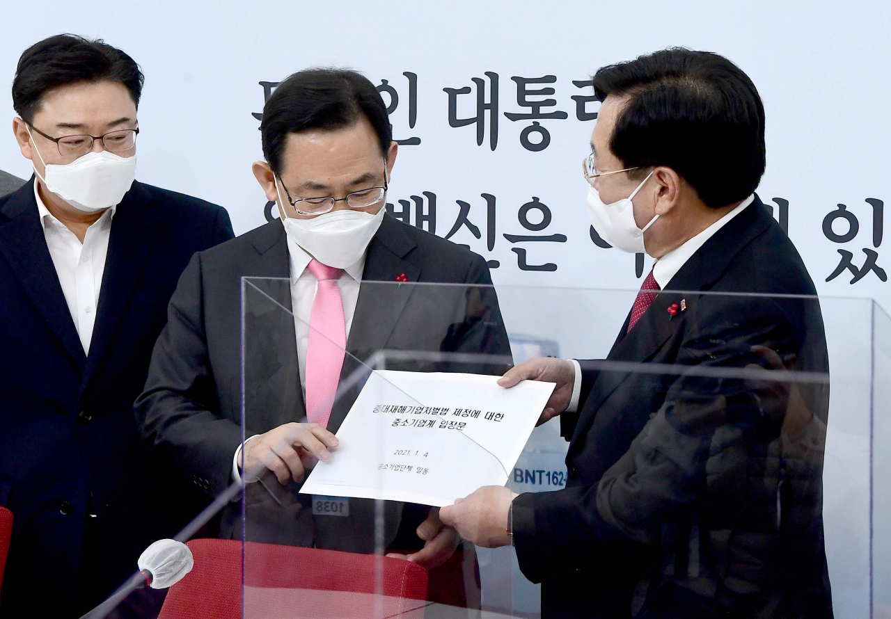 주호영 국민의힘 원내대표가 4일 서울 여의도 국회에서 열린 국민의힘-중소기업단체협의회 단체장 간담회에서 김기문 중소기업중앙회장으로부터 ‘중대재해기업처벌법 제정에 대한 중소기업계 입장문’을 전달받고 있다. [헤럴드경제=이상섭 기자]