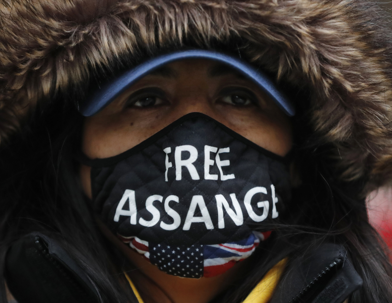 A Julian Assange supporter wears a face mask bearing his name outside the Old Bailey in London, Monday, Jan. 4, 2021. (AP-Yonhap)