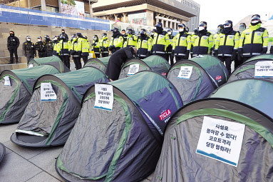 지난달 31일 오후 서울 종로구 광화문광장 해치마당에서 서울장애인차별철폐연대 관계자들이 장애인 거주시설 집단감염 긴급 분산조치 및 코호트 격리 중단 결정 촉구 농성에 돌입하며 텐트를 설치하고 있다. [연합]