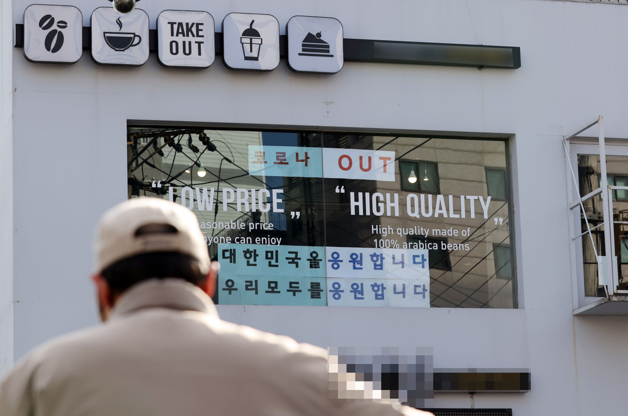 5일 오후 서울 관악구 신림동의 한 카페 유리창에 '코로나 OUT' 문구가 붙어있다. 신종 코로나바이러스 감염증 확산 영향으로 정부가 최근 '카페 홀 이용금지' 조치를 2주 더 연장하자 업주들이 이에 반발하며 공동 대응에 나서고 있다. 연합뉴스