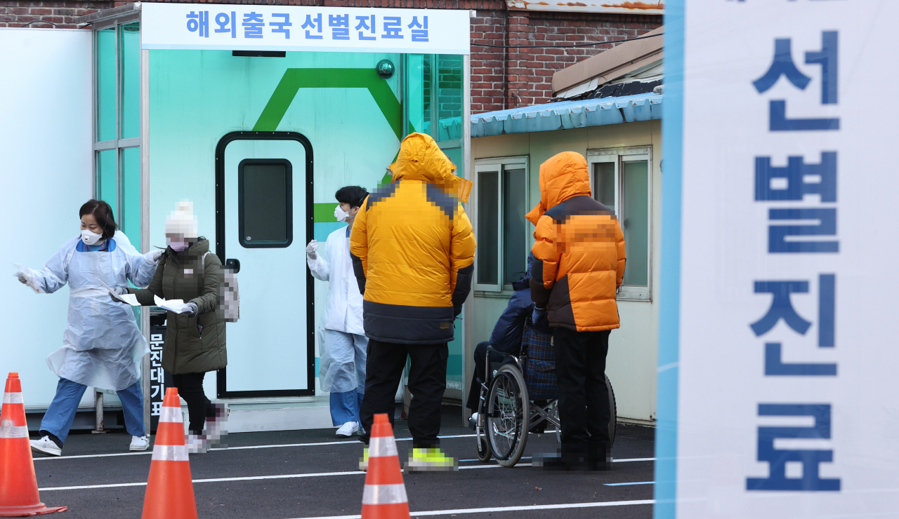 국내 신종 코로나바이러스 감염증(코로나19) 신규 확진자 수가 1078명을 기록한 16일 오전 서울 중구 국립중앙의료원 코로나19 해외출국선별진료실에서 의료진이 시민에게 검사 안내를 하고 있다. 연합뉴스