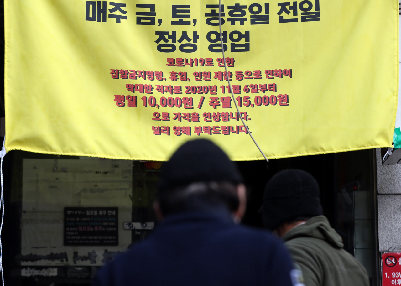 6일 오전 서울의 한 요리주점 앞에 “코로나19로 인한 집합금지명령, 휴업, 인원제한 등으로 인한 막대한 적자로 가격을 인상합니다” 라고 적힌 현수막이 붙어 있다. 신종 코로나바이러스 감염증 장기화로 사회적 거리두기 강화 조치가 연장되자 이에 반발하는 자영업자들의 움직임이 심상치 않은 가운데 헬스장에 이어 노래방·호프집·PC방 등으로도 반발이 확산하는 모양새를 보이고 있다. [연합]