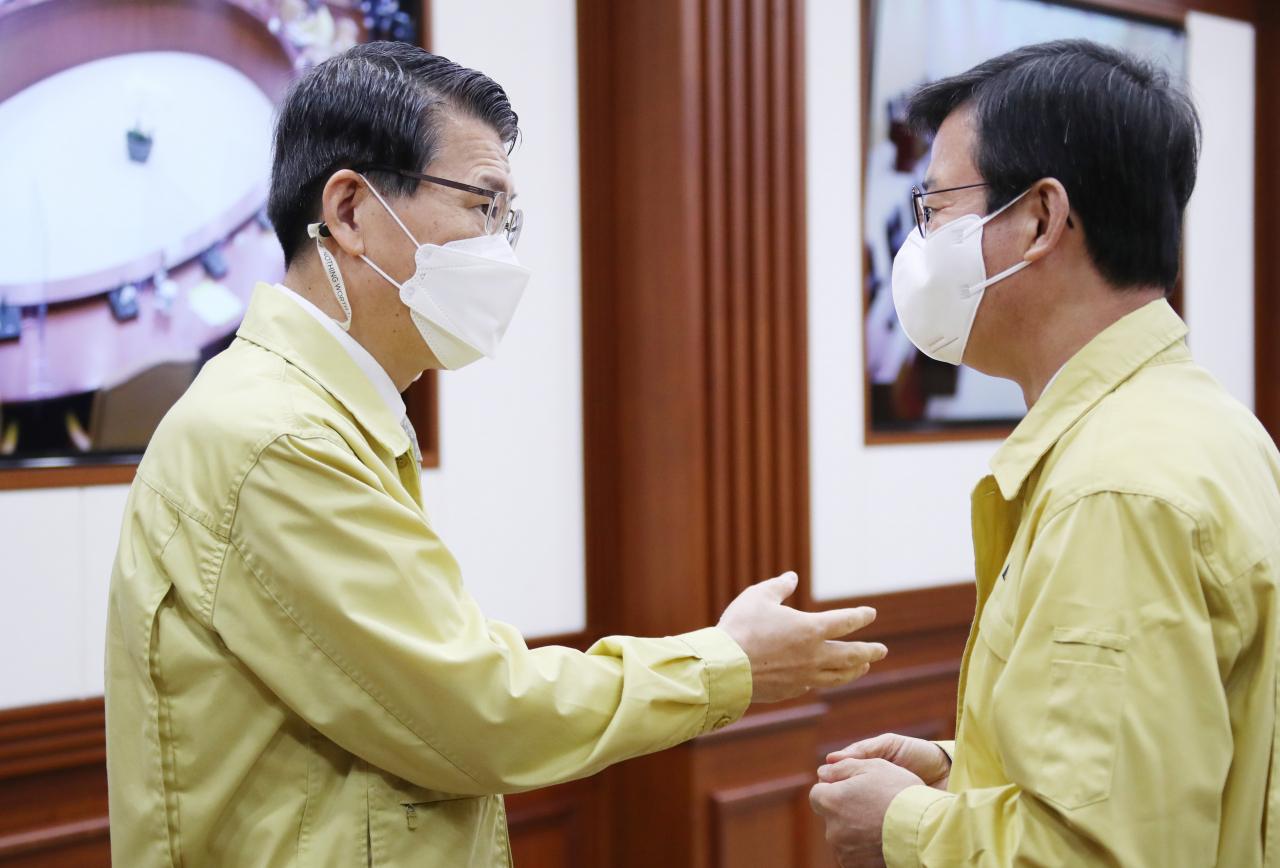 문성혁 해양수산부 장관(오른쪽)과 은성수 금융위원장이 6일 정부서울청사에서 열린 제25차 비상경제 중앙대책본부 회의 겸 제8차 한국판 뉴딜 관계장관회의에 참석해 대화하고 있다. 연합뉴스