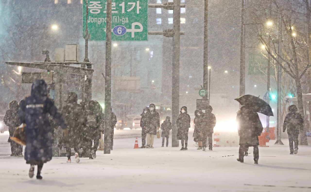 서울 전역에 대설주의보가 발효된 6일 저녁 서울 광화문역 인근에서 시민들이 퇴근길을 재촉하고 있다. [연합]