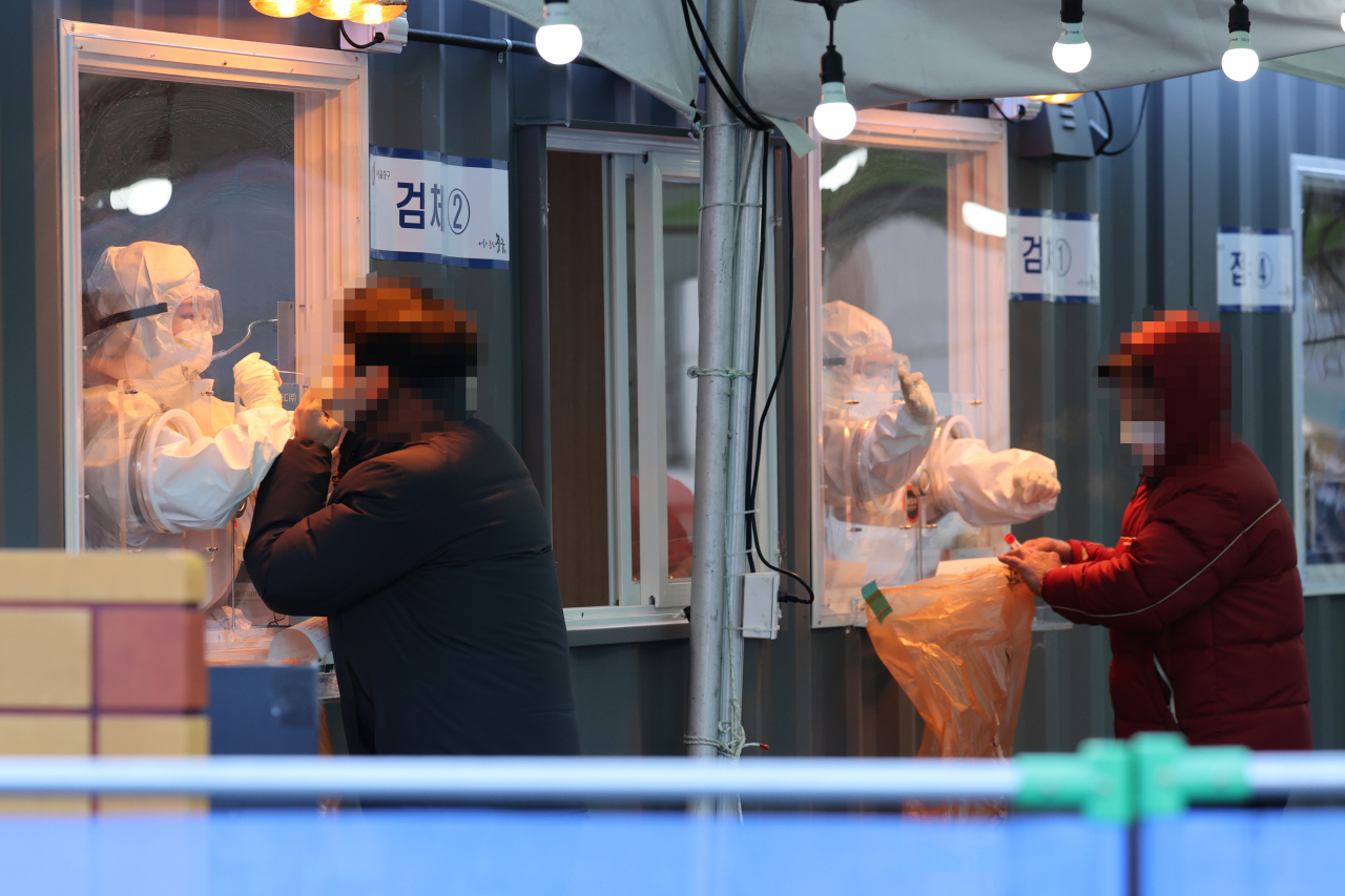 6일 오전 서울역 앞에 마련된 임시선별진료소에서 의료진이 검체채취를 하고 있다. [연합]