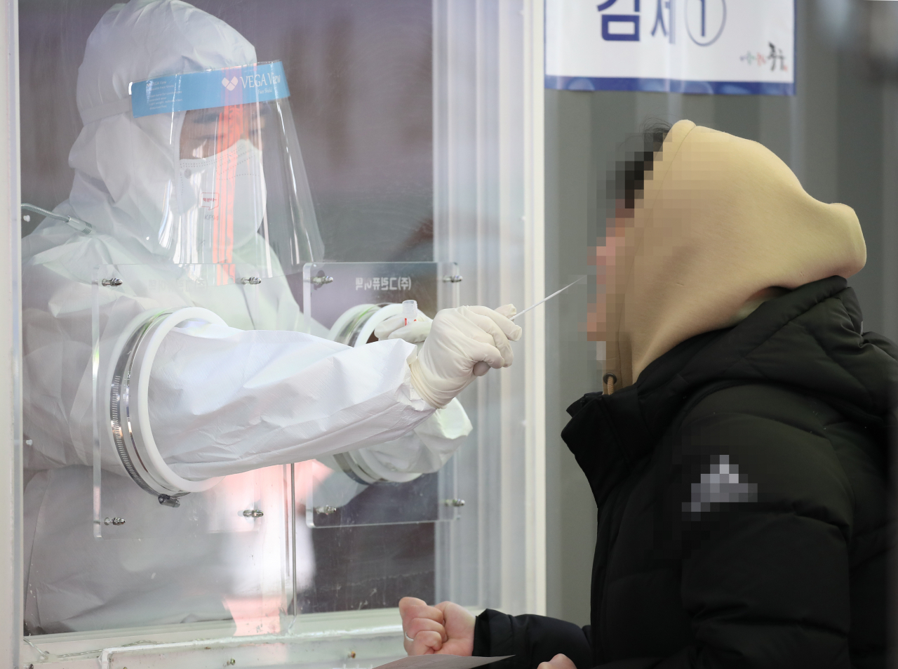 임시 선별검사소를 찾은 시민이 콧속 깊숙이 면봉을 넣는 비인두도말법으로 검체 검사를 받고 있다.[연합]