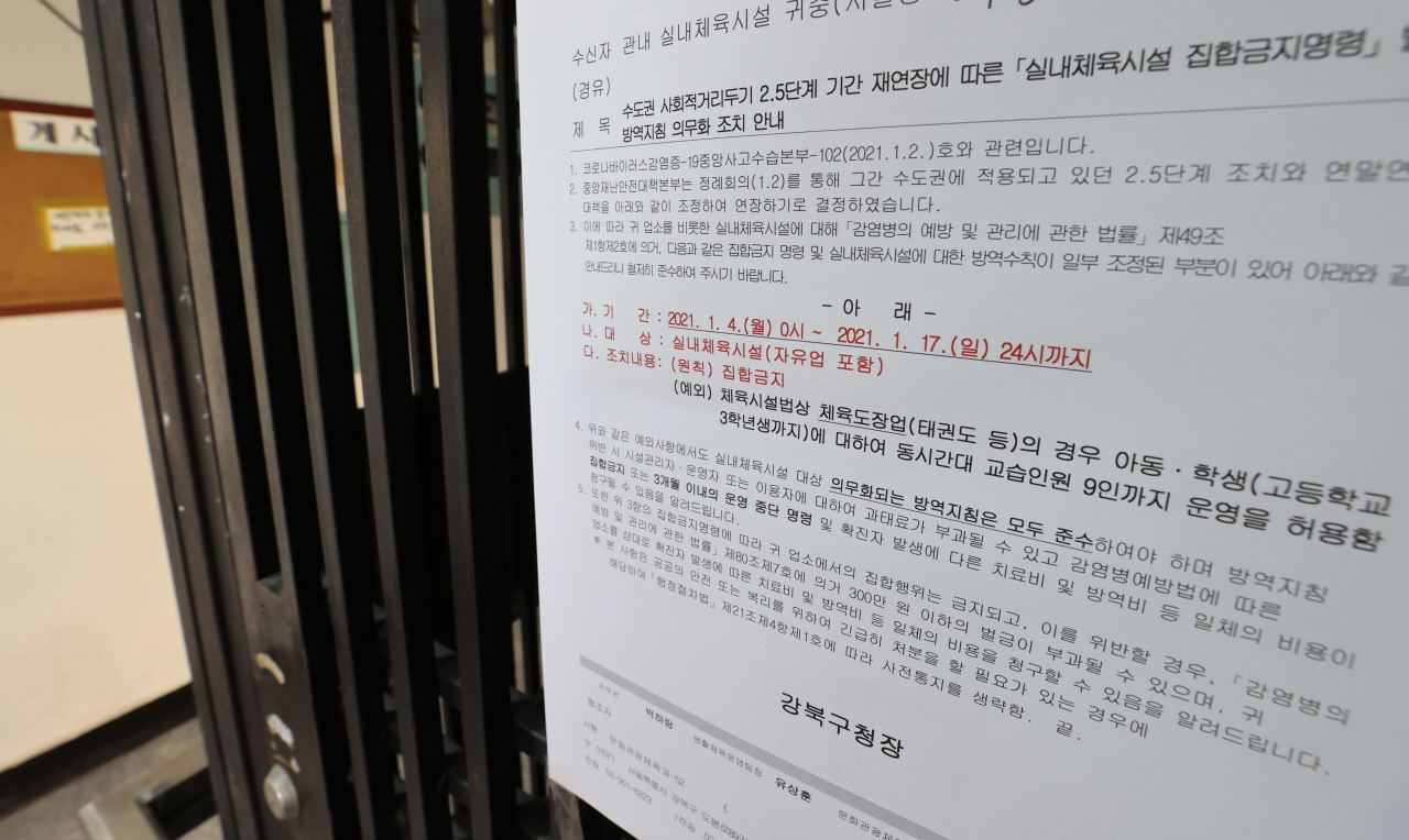 6일 오후 서울 시내 한 무에타이, 킥복싱체육관에 실내체육시설 집합금지명령을 알리는 공문이 부착돼있다. 정부는 4일부터 체육시설의 설치·이용에 관한 법률 시행규칙에 따라 체육도장업에 속하는 체육관은 아동·학생을 대상으로 9인 이하의 영업을 할 수 있도록 규제를 완화했다. 체육시설법에 따르면 체육도장업의 운동 종목은 대한체육회 가맹 경기 단체에서 행하는 운동으로 권투, 레슬링, 태권도, 유도, 검도, 우슈, 합기도 등 7개 종목을 뜻한다. 이에 따라 대한체육회 가맹 종목이 아닌 체육관은 체육도장이 아닌 실내 체육시설로 분류되고, 집합금지 완화 대상에서도 제외된다. 연합뉴스