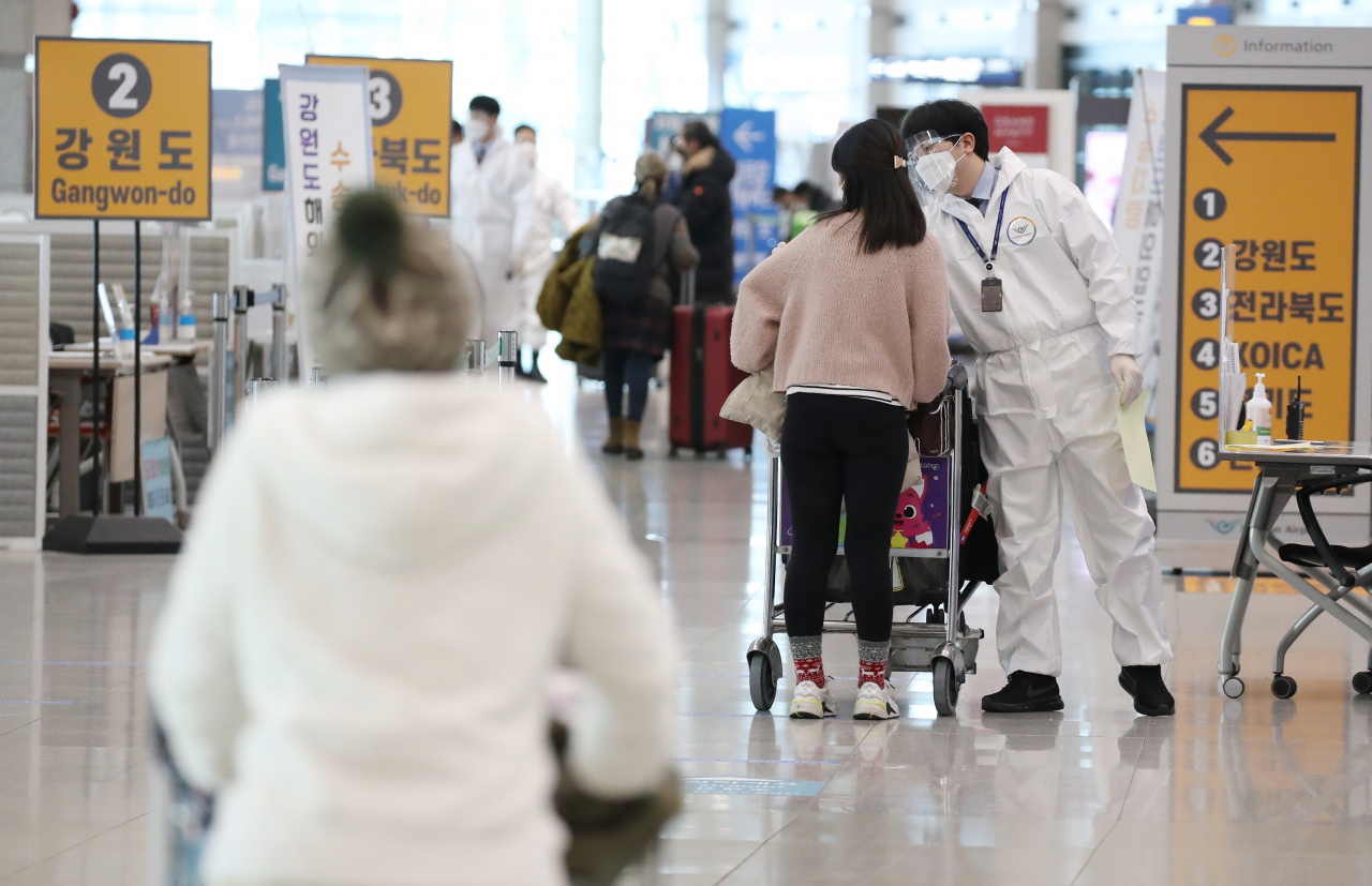 국내에서 영국발 코로나19 변이 바이러스 감염자가 추가로 확인되고 있는 가운데 6일 오전 인천국제공항 1터미널 입국장에서 방역 관계자들이 해외입국자들에게 식별 스티커를 부착해주고 있다. 연합뉴스
