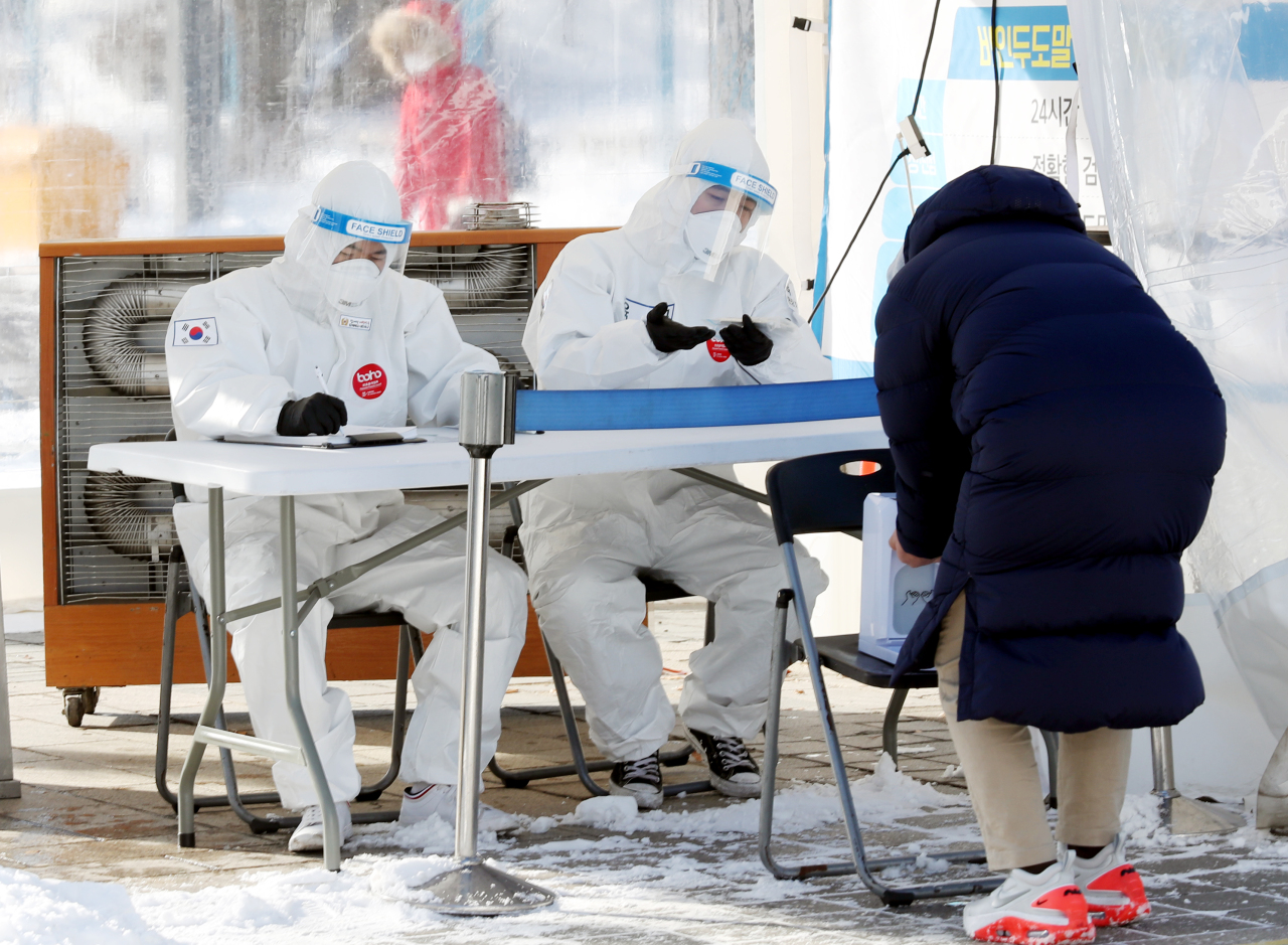 Medical workers process COVID-19 checks Thursday at a temporary diagnostics center made in Incheon. (Yonhap)