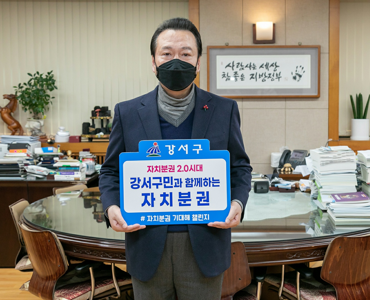 노현송 서울 강서구청장이 7일(목) 구청장실에서 「자치분권 2.0시대, 강서구민과 함께하는 자치분권」이라고 적힌 손팻말을 들어 보이며 기념촬영을 하고 있다. [강서구 제공]