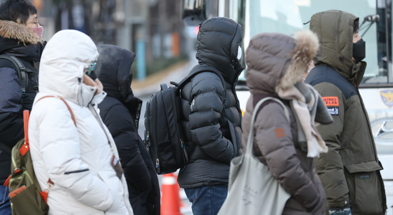 전국적으로 영하 20도를 넘나드는 북극발 최강 추위가 절정에 달한 8일 오전 서울 종로구 광화문 네거리에서 직장인들이 두꺼운 방한복을 입고 출근하고 있다. [연합]