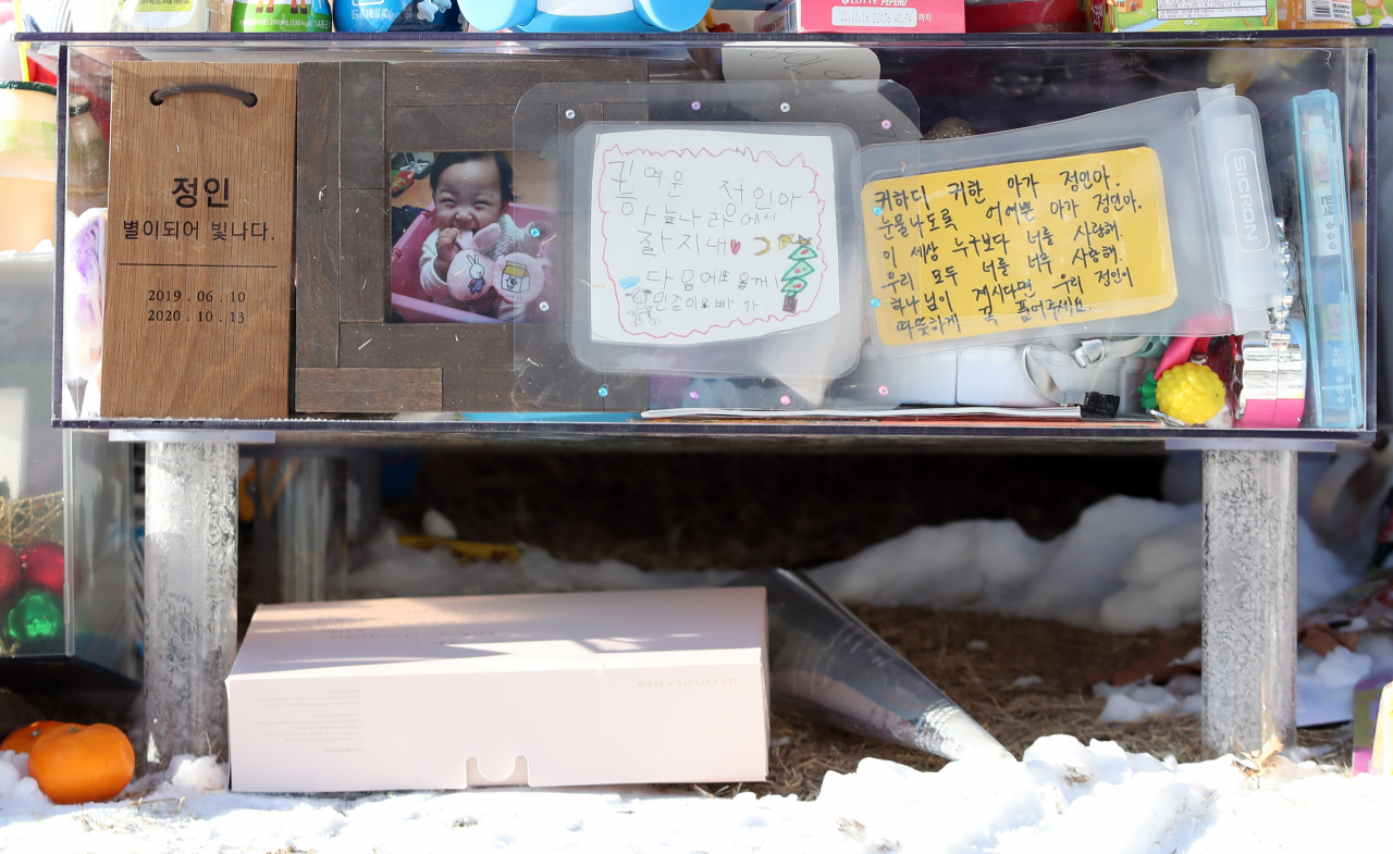 지난 8일 경기 양평군 하이패밀리 안데르센 공원묘원에 양부모의 학대로 생후 16개월 만에 사망한 정인이를 추모하며 시민들이 가져다 놓은 사진과 꽃 등이 놓여 있다. [연합]