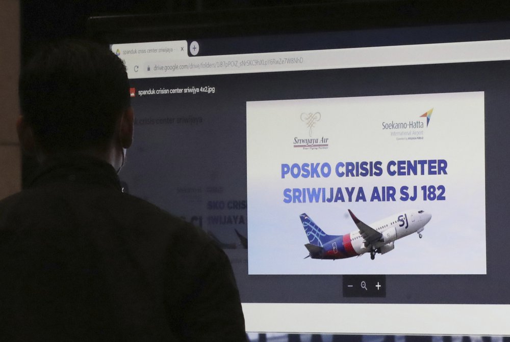 A man stands near an LCD screen installed at a crisis center set up following a report that a Sriwijaya Air passenger jet has lost contact with air traffic controllers after take off, at Soekarno-Hatta International Airport in Tangerang, Indonesia, Saturday. A Sriwijaya Air passenger jet with 56 passengers and six crew members onboard, lost contact with air traffic controllers after taking off from Indonesia's capital on Saturday on a domestic flight, officials said. (AP-Yonhap)