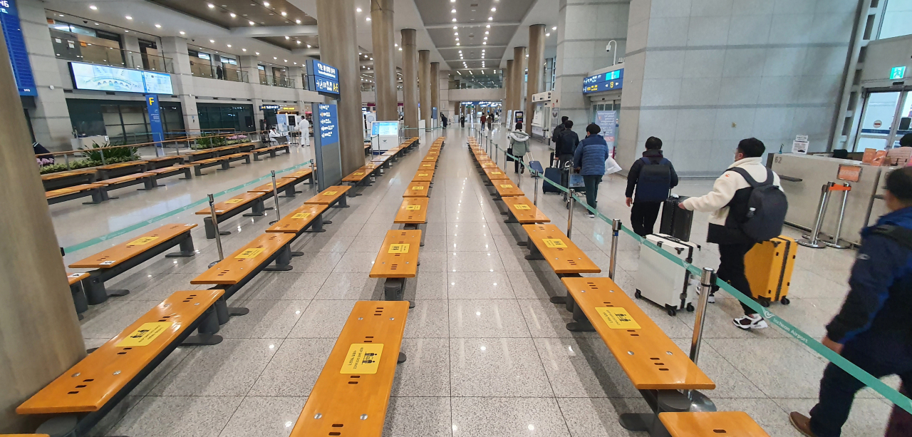 인천공항 도착장에 거리두기 안내문이 붙은 의자들이 줄지어 있다. [연합]