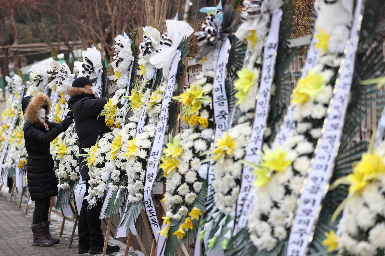 대한아동학대방지협회 관계자들이 11일 오전 서울남부지검·서울남부지법 앞에 정인이 양부모에 대한 엄벌을 촉구하며 근조 화환과 바람개비를 설치하고 있다. [연합]