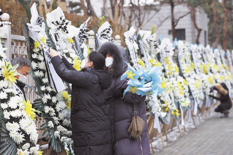 대한아동학대방지협회관계자들이 11일 오전 서울 양천구 남부지방검찰청과 남부지방법원 앞에 정인이 양부모에 대한 엄벌을 촉구하며 근조화환과 바람개비를 설치하고 있다. 법원은 13일 아동학대처벌법 위반 등 혐의로 구속기소된 양모 장모씨와 아동복지법 위반 등 혐의를 받는 양부 안모씨의 첫 공판을 연다. [연합]