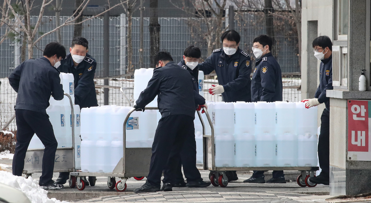 동부구치소의 수용자들과 직원에 대한 코로나19 8차 전수조사가 진행중인 11일 오후 서울 송파구 동부구치소에서 관계자들이 소독제를 옮기고 있다. [연합]