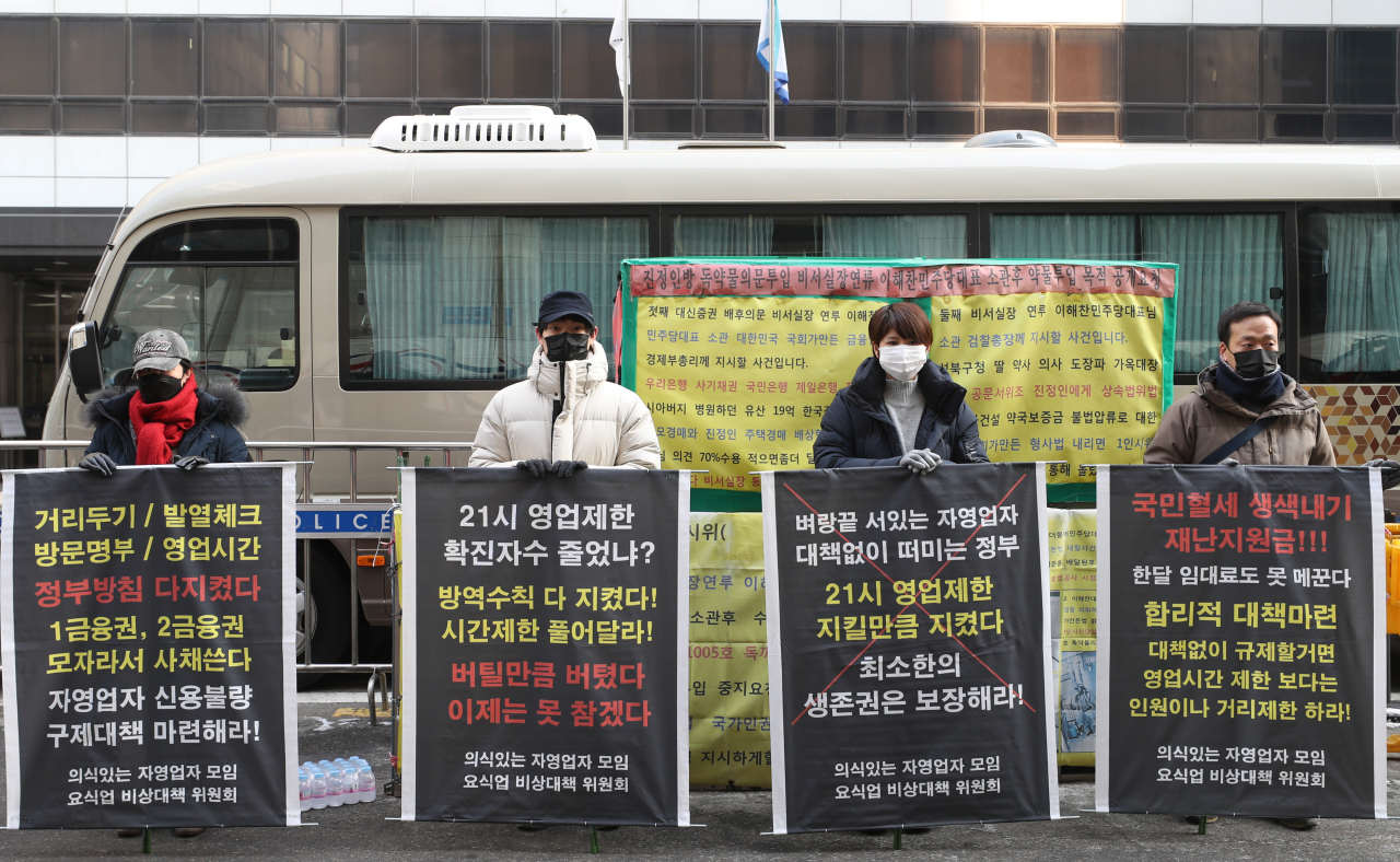 Members of a coalition for the rights of restaurant businesses stage a protest Tuesday near the headquarters of the ruling Democratic Party in Yeouido, western Seoul, to demand the government to remove of 9 p.m. operation deadline under COVID-19 social distancing rules. (Yonhap)