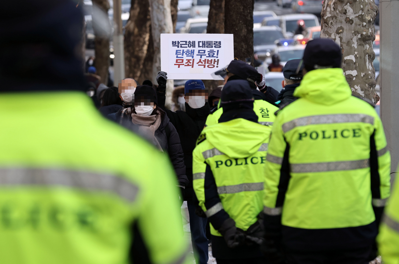 박근혜 전 대통령의 재상고심 선고 공판이 열린 14일 오전 서울 서초역 인근에서 박 전 대통령 지지자들이 손팻말을 들고 있다. 대법원은 이날 특정범죄 가중처벌법상 뇌물 등 혐의로 기소된 박 전 대통령의 재상고심에서 징역 20년·벌금 180억원을 선고한 원심을 확정했다. [연합]