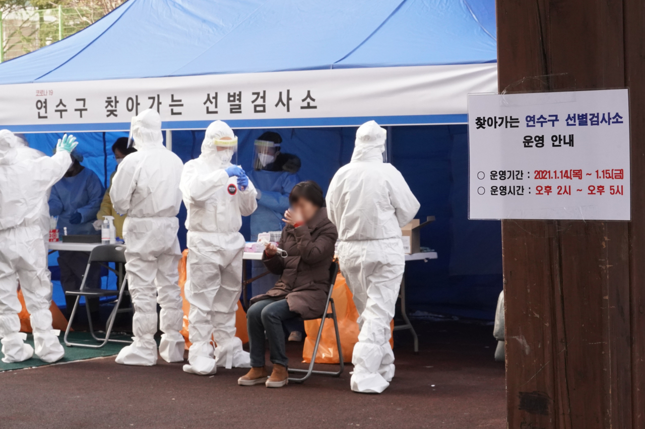14일 오후 인천시 연수구 한 아파트에 설치된 선별검사소에서 주민들이 신종 코로나바이러스 감염증(코로나19) 검체 검사를 받고 있다. 이 아파트에서는 지난 10일부터 이날까지 주민 8명이 코로나19 확진 판정을 받았다. 연합뉴스