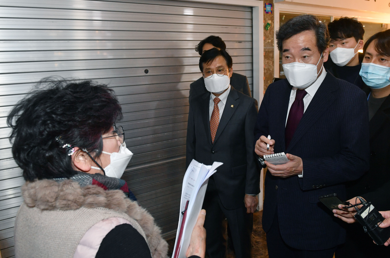 이낙연 더불어민주당 대표가 지난 14일 서울 영등포 지하상가 내 문을 닫은 상가 앞에서 상인들의 고충을 듣고 있다. [국회사진기자단]