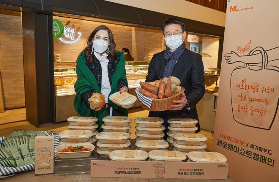 올가홀푸드 강병규 대표(오른쪽)와 주한 네덜란드대사관 겔라레 나더르 농무참사관(왼쪽)이 15일 올가 방이점에서 열린 제로 푸드웨이스트 캠페인 행사를 마친 후 제로 푸드웨이스트 요리에 활용된 못난이 농산물을 들고 기념촬영을 하고 있다. [사진=풀무원]
