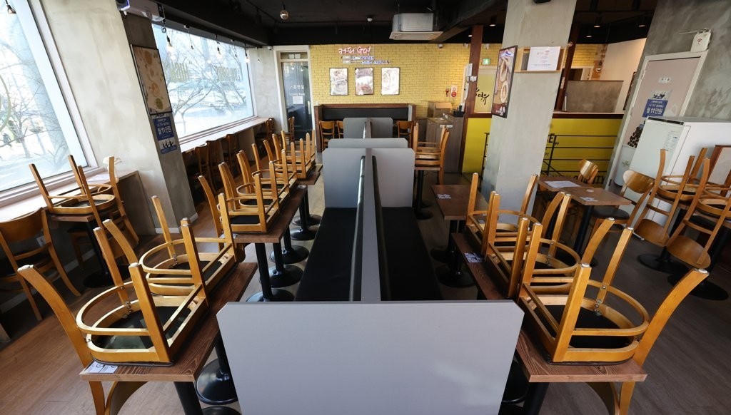 In this file photo, chairs are turned upside down on tables at a cafe in southern Seoul on Jan. 6, 2021, amid the government's COVID-19 restrictions on dining in at coffee shops. (Yonhap)