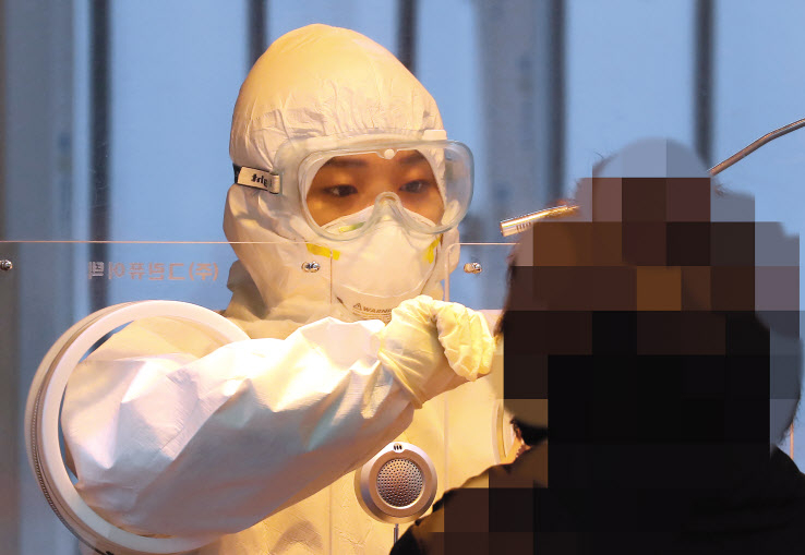18일 오전 서울역에 마련된 임시선별검사소에서 의료진이 검체 채취를 하고 있다. 코로나19 신규 확진자 수가 지난해 11월말 이후 처음으로 300명대로 줄어든 가운데 정세균 국무총리는 이날 중대본 회의에서 백신 시장은 철저히 공급 우위의 시장이라며 “우리가 계약을 맺은 5600만명분의 백신도 국내에 도착해야 안심할 수 있다”고 말했다. [연합]