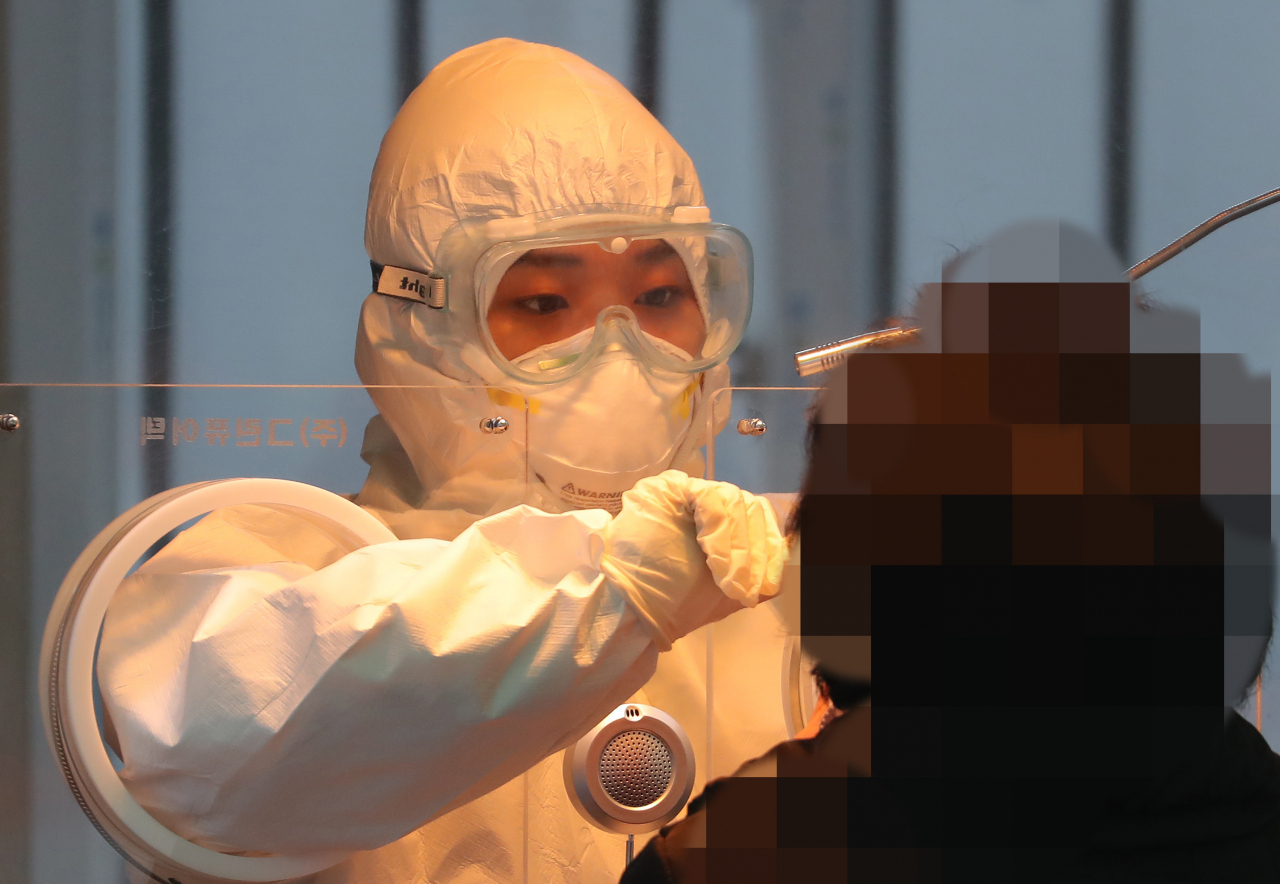 18일 오전 서울역에 마련된 임시선별검사소에서 의료진이 검체 채취를 하고 있다. 연합뉴스