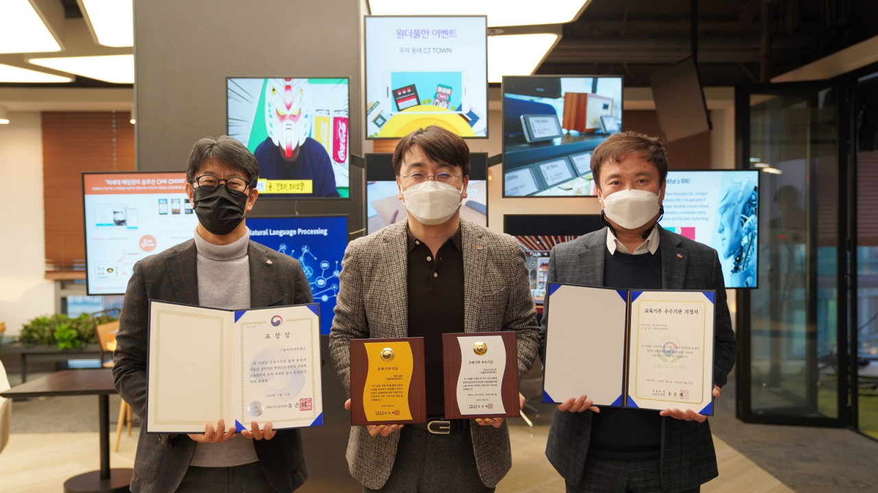 CJ올리브네트웍스 차인혁 대표이사(가운데)와 경영지원담당 백재민 상무(왼쪽)가 서울시 용산구 본사에서 상장과 상패를 들고 기념 사진을 촬영하고 있다. [CJ올리브네트웍스 제공]