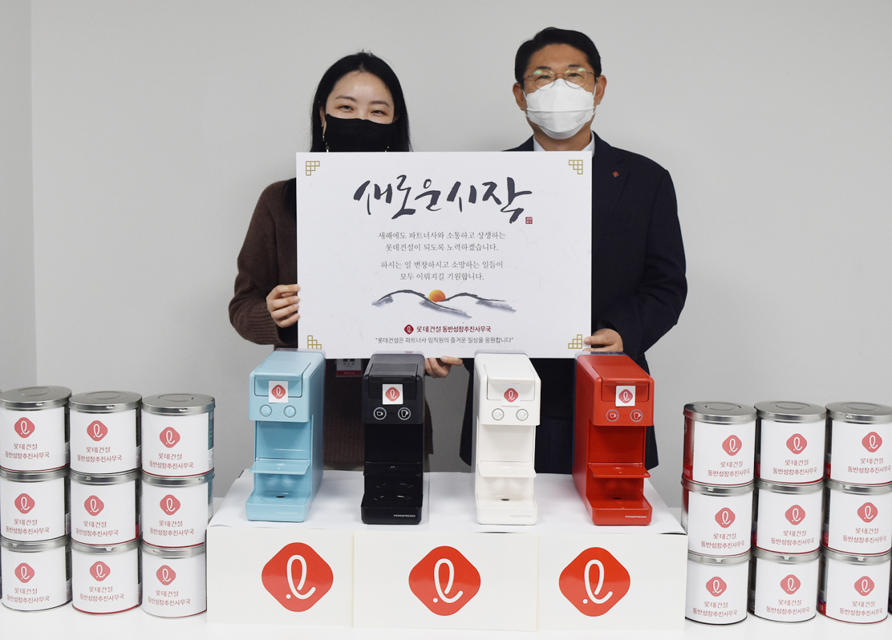 롯데건설이 우수 파트너사에 지급하는 새해 선물인 커피머신(오른쪽 롯데건설 박은병 외주구매본부장)[롯데건설 제공]