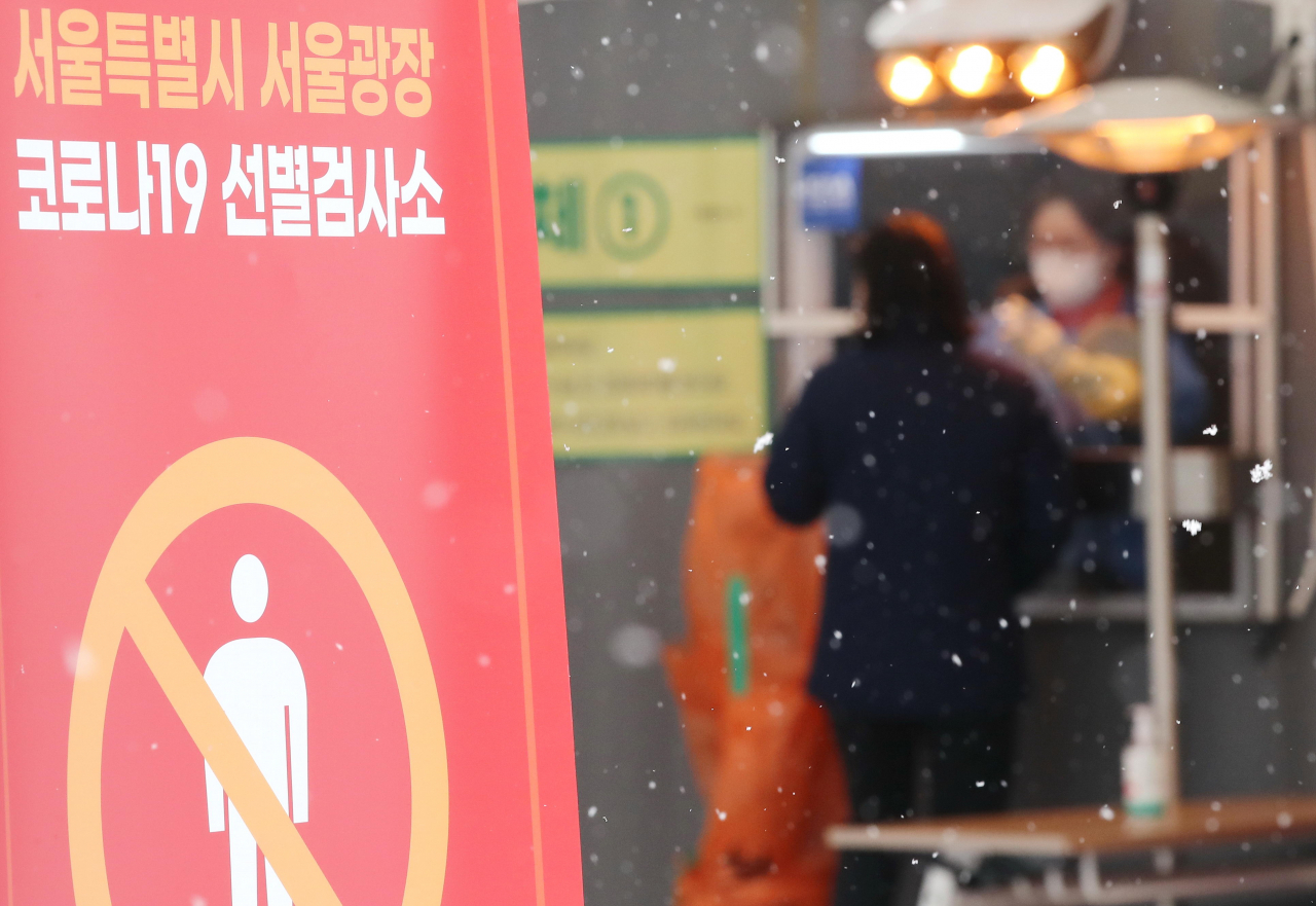 지난 18일 오전 서울광장에 마련된 코로나19 임시 선별검사소에서 의료진이 검체 채취를 하고 있다. [연합]