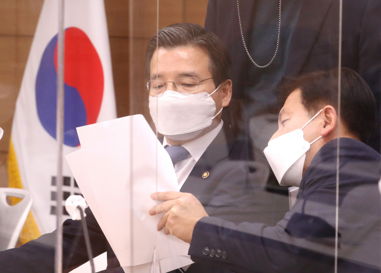 김용범 기획재정부 1차관(왼쪽)이 지난 18일 오후 세종시 정부세종청사에서 '2021년 업무계획 발표' 배경 브리핑에 앞서 배석자와 자료를 살피고 있다. 김 차관은 19일 비대면 방식으로 열린 한국판 뉴딜 자문단 디지털 뉴딜 분과 제3차 회의에서 "총 7조6000억원의 디지털 뉴딜 예산을 상반기 70% 목표로 조기 집행하겠다"고 말했다.[연합]
