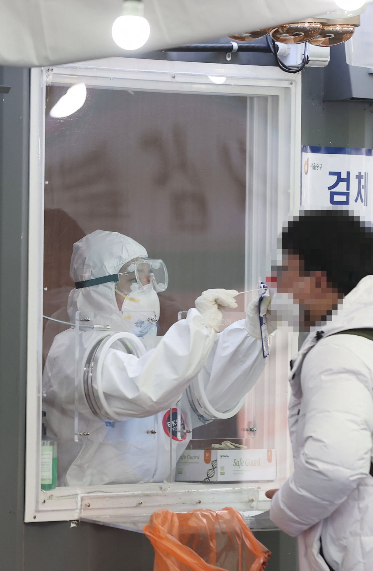 국내 신종 코로나바이러스 감염증(코로나19) 첫 환자가 나온 지 꼭 1년째 되는 날인 20일 신규 확진자 수는 400명대 초반을 기록했다. 300명대 후반이었던 전날보다 다소 늘어나면서 400명대로 올라섰다. 이날 오전 서울역 광장에 마련된 신종 코로나바이러스 감염증(코로나19) 임시선별진료소에서 의료진이 검체 채취를 하고 있다. 연합뉴스