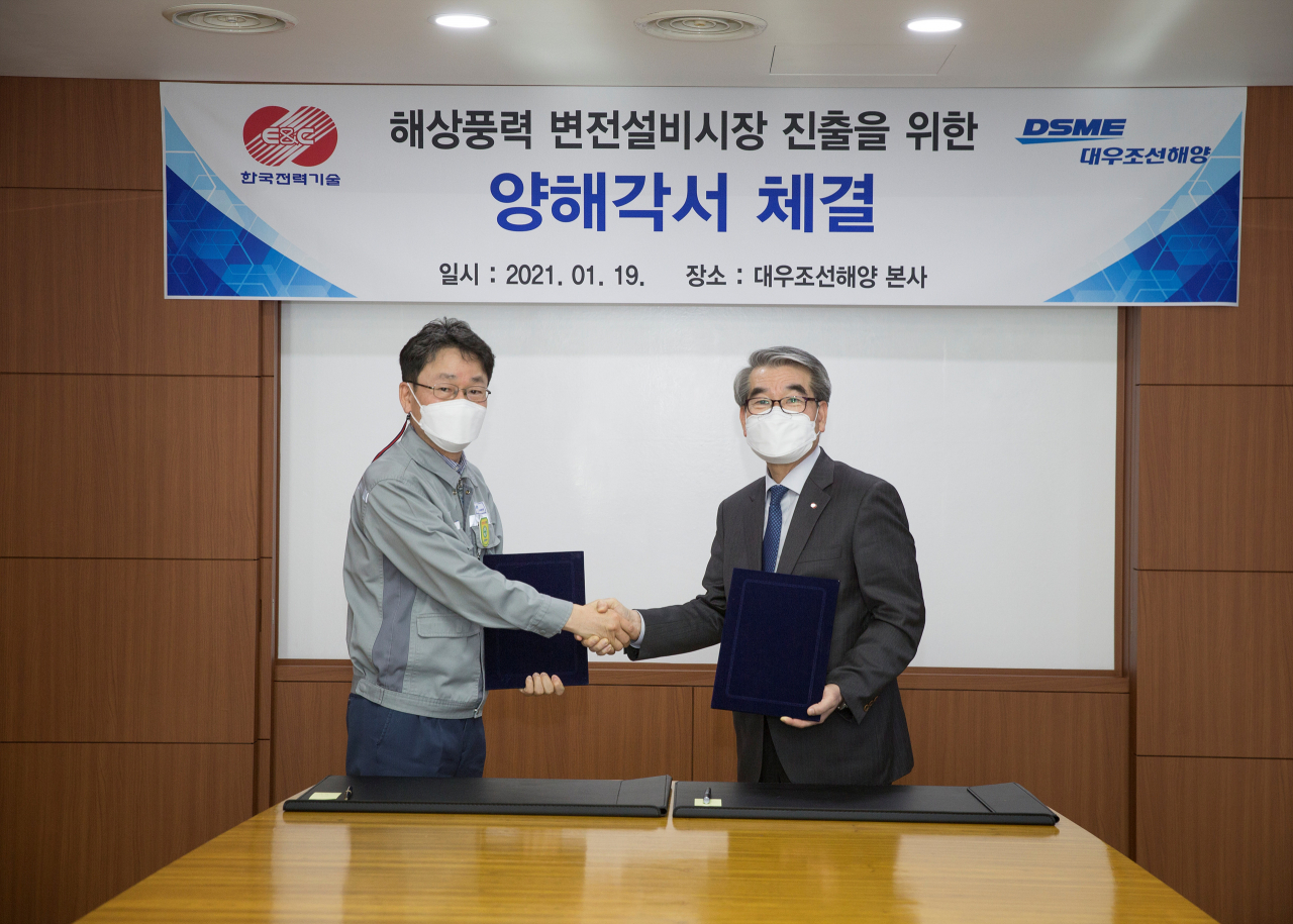 지난 19일 대우조선해양 본사인 옥포조선소에서 열린 ‘해상풍력 변전설비시장 진출을 위한 양해각서 체결식’에서 대우조선해양 기술본부장 우제혁 전무(왼쪽)와 한국전력기술 에너지신사업 본부장 김동규 전무가 양해각서에 서명한 뒤 기념촬영을 하고 있다. [대우조선해양 제공]